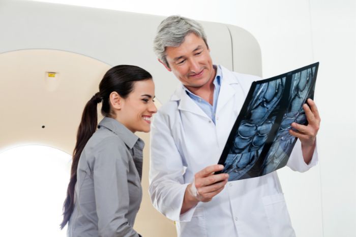 physician and patient looking at x-ray file