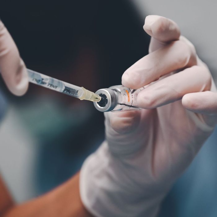 A vaccine being placed onto a needle syringe