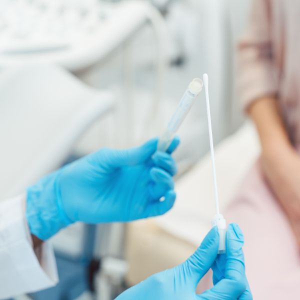 A cotton swab being placed into a container