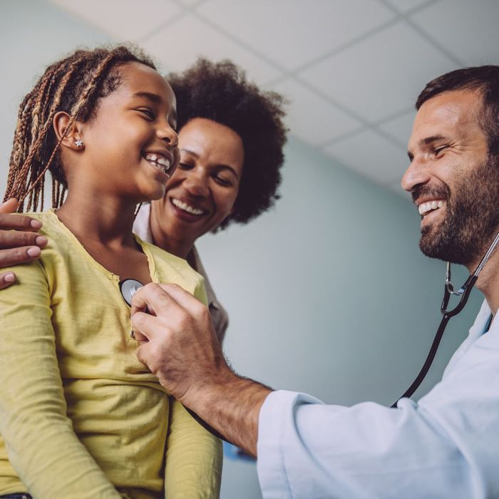 A child getting her heart measured by a doctor