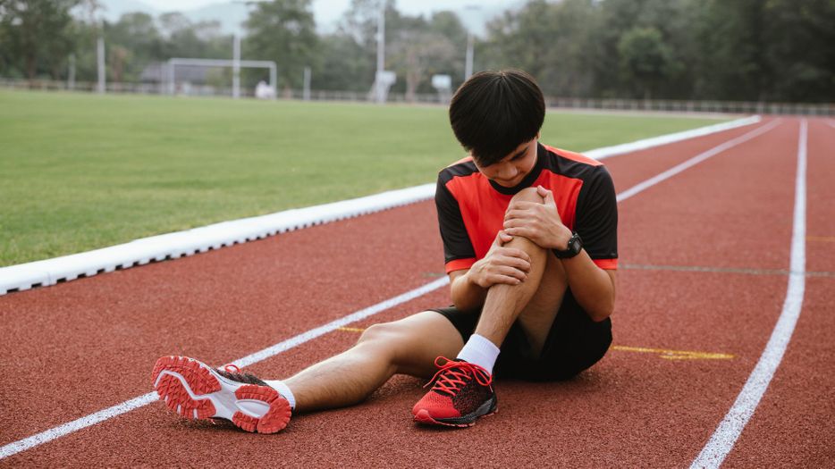 Child clutching at his knee in pain