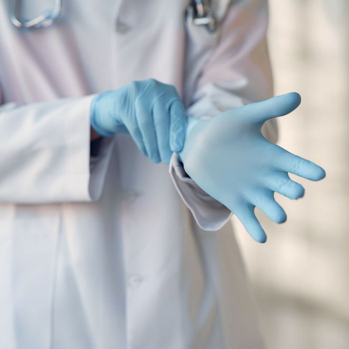 A doctor putting on gloves