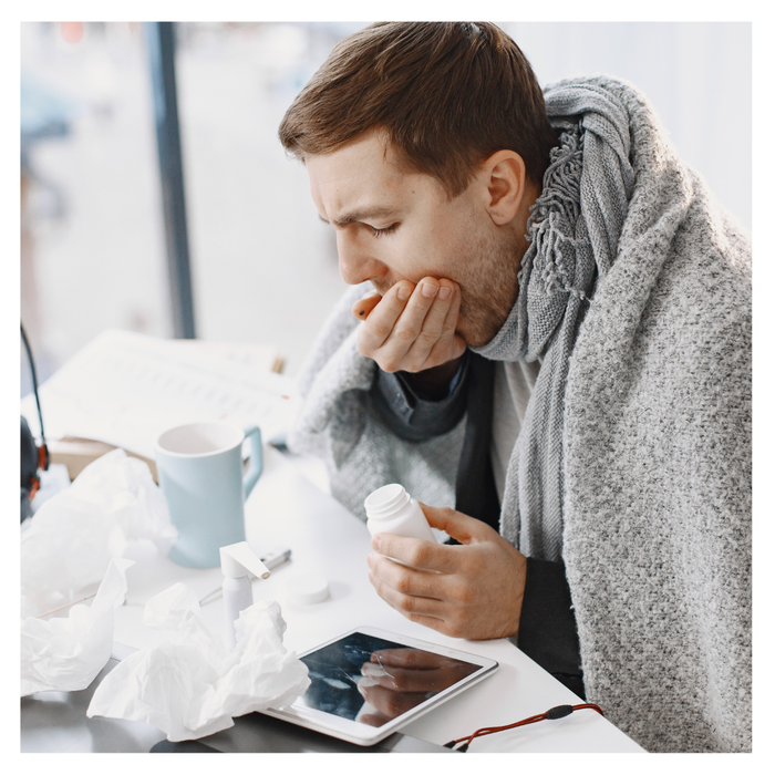 A sick man coughing and taking medicine 