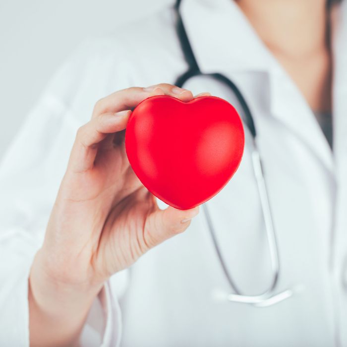 Doctor holding up a toy heart