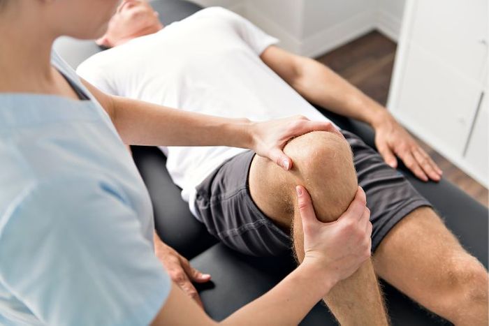 Medical professional examining a patient's knee