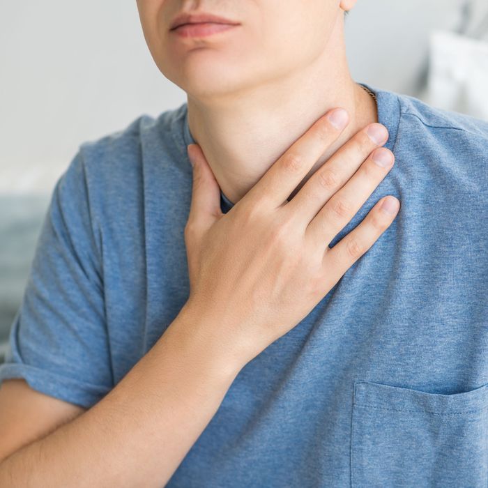 Person grabbing his throat in pain 