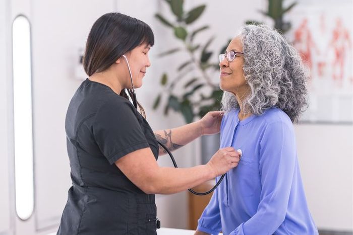 Medical professional using a stethoscope on a patient