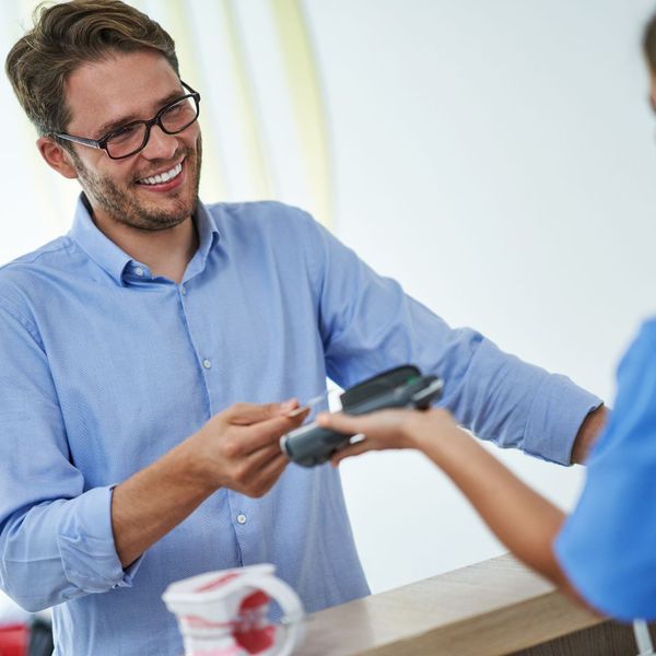 man paying at dentist