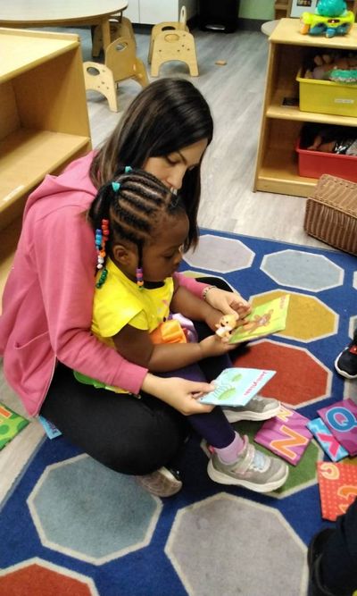 Teacher Reading to Infant at Ivy Prep