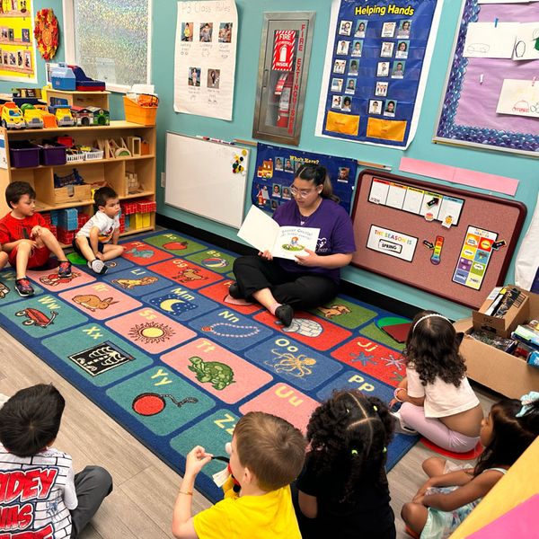 children being read to by preschool teacher children being read to by preschool teacher