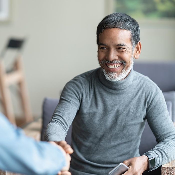 Smiling man shaking the hand of a therapist