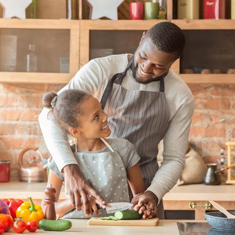 Father cooking in the kitchen with his daughter.