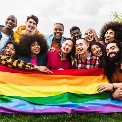 A group holding an LGBTQ flag