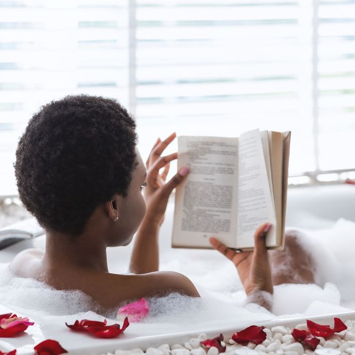 woman reading book in tub