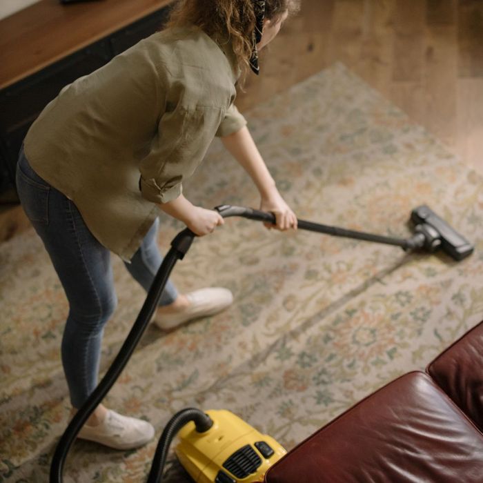 woman vaccuuming carpet