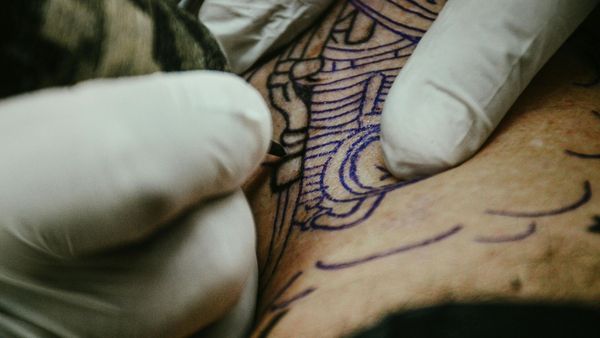tattoo artist working on line work
