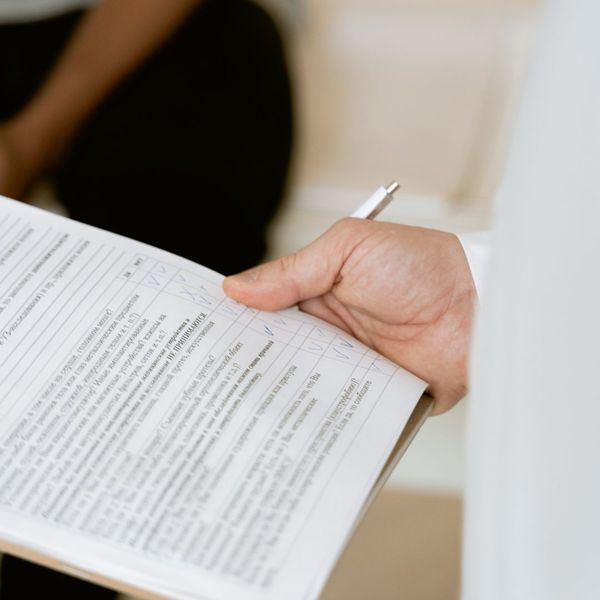 person holds checklist on clipboard and pen How Lee H Moultrie & Associates LLC Simplifies Your Life Insurance Choices 1.jpg