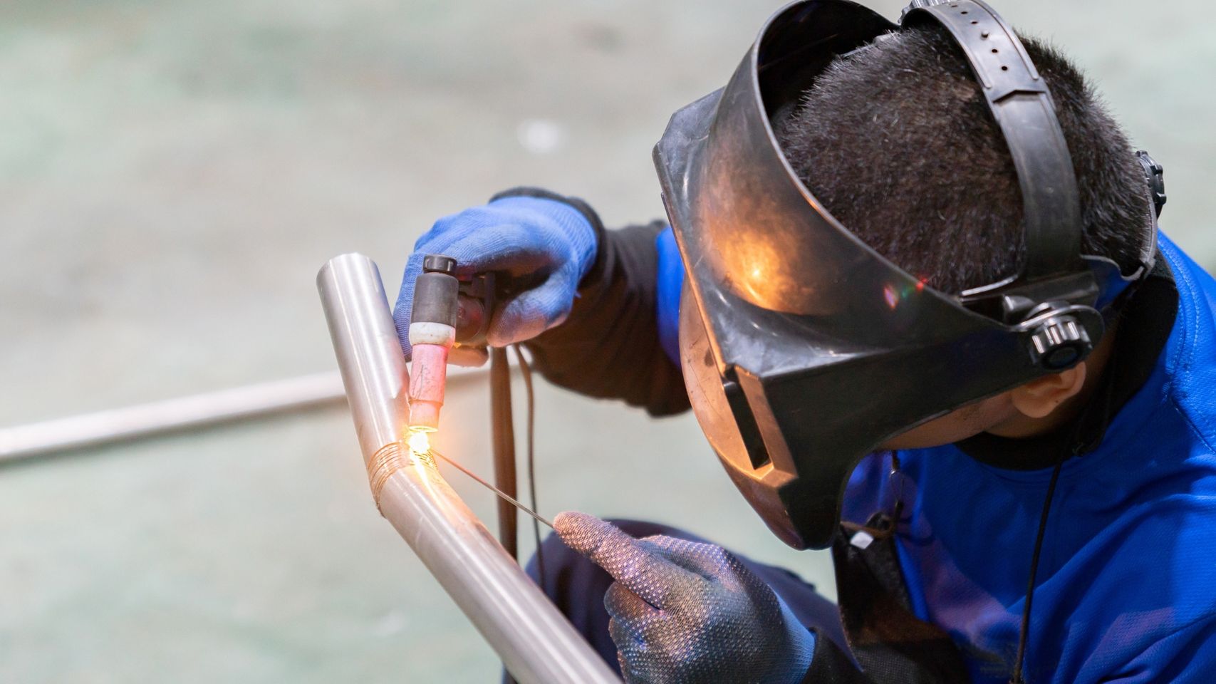 Professional welder examining completed structural steel joint.