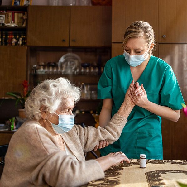 nurse helping elderly woman