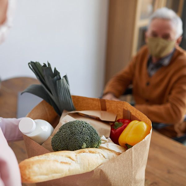 woman delivering food to elderly man