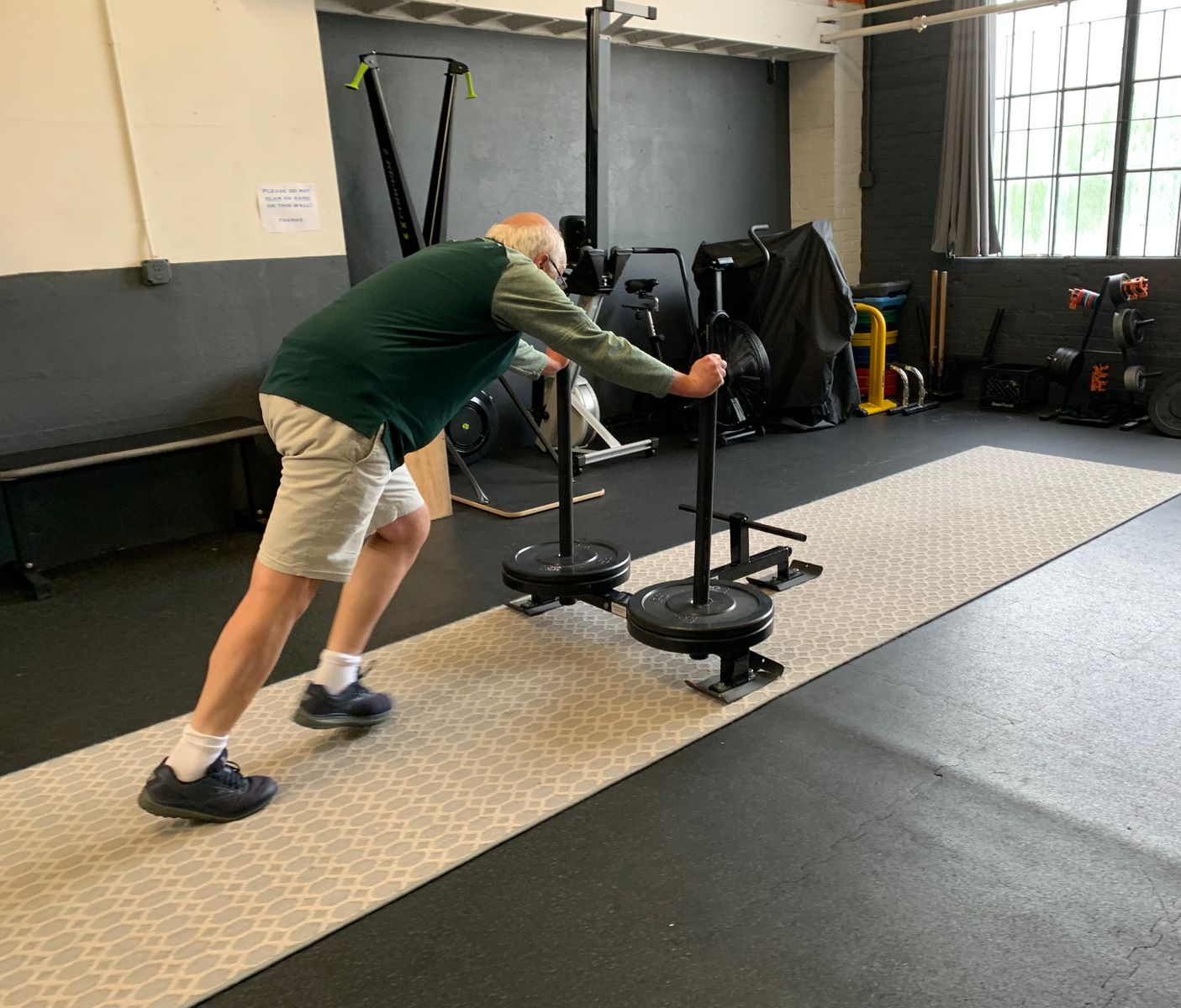 Man pushing weights across the floor