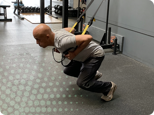photo of man working with TRX ropes