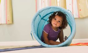 toddler climbing through toy