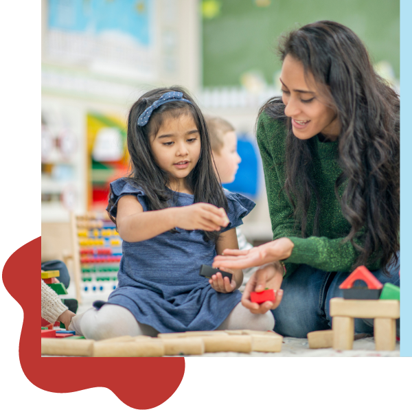 teacher helping a girl with blocks