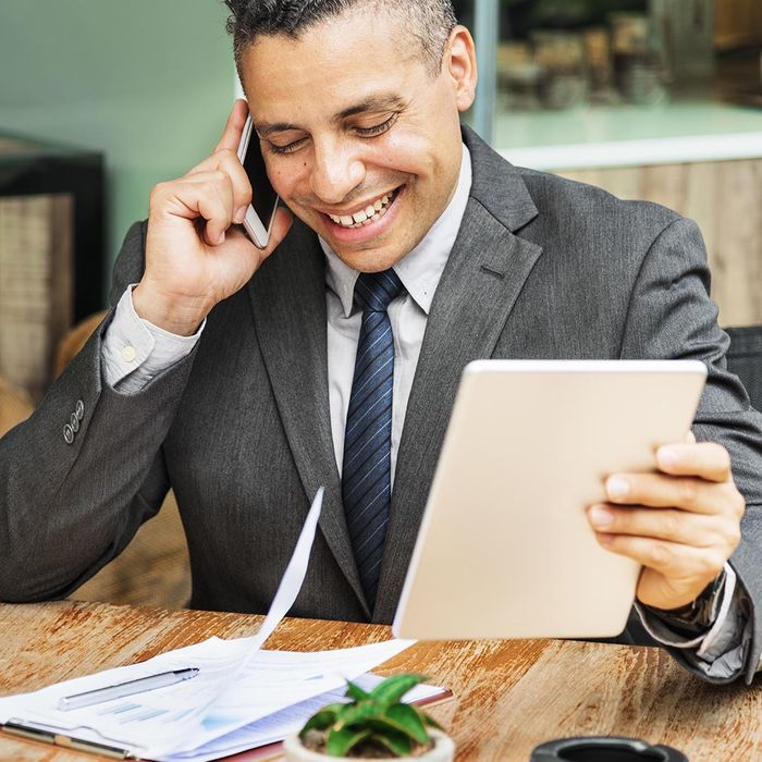 smiling business man on the phone and holding a tablet