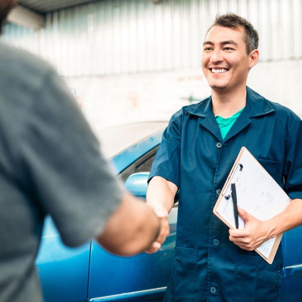 happy mechanic shaking customer hand