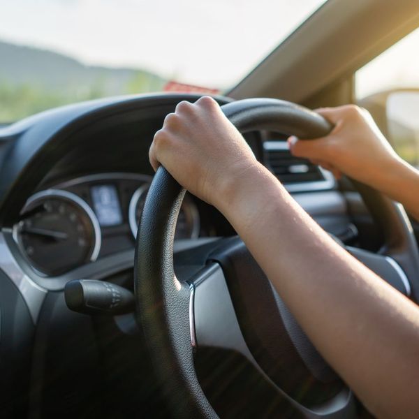 person with hands on steering wheel