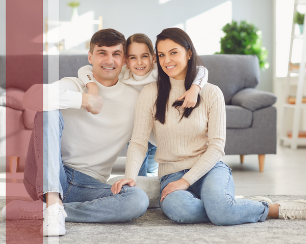 Two happy parents and their young daughter posing for a picture in their living room