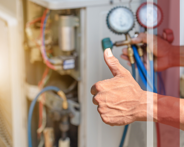 HVAC tech holding a diagnostics gauge and giving a thumbs up