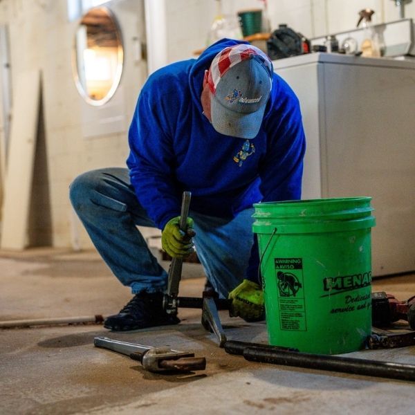 Professional plumber performing essential floor drain or leak repair.