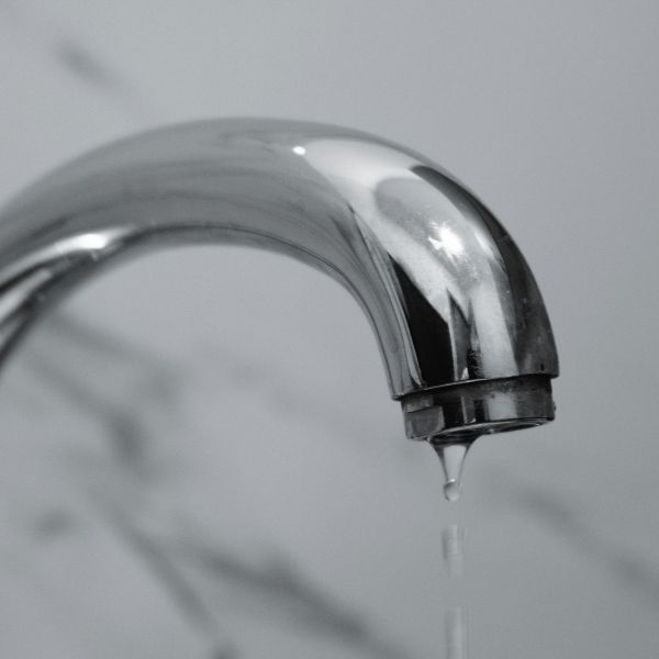 Water dripping from a leaky faucet, signaling need for plumbing repair.