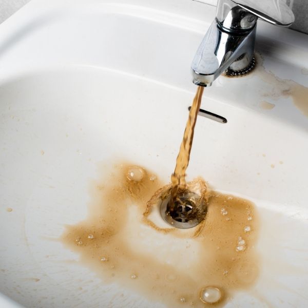 Warning sign: Faucet running brown or rusty water due to pipe corrosion.