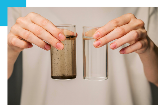 a woman's hands holding a glass of dirty water and a glass of clean water