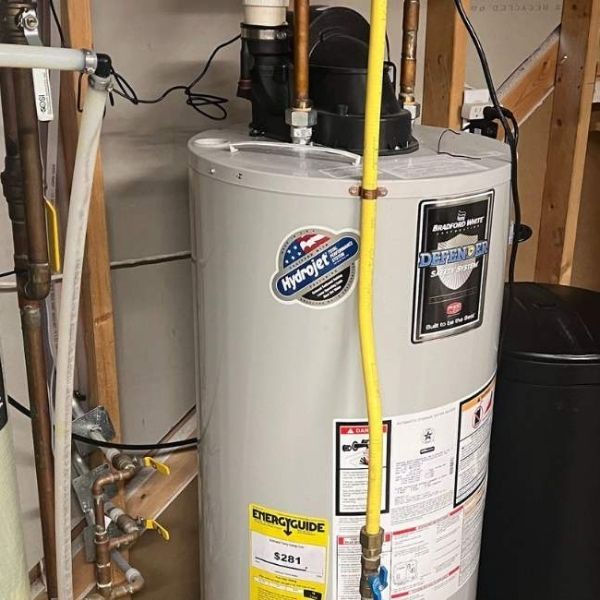 Inspecting a large residential tank water heater for service or replacement.