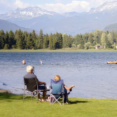 Older couple sitting in chairs at mountain lake