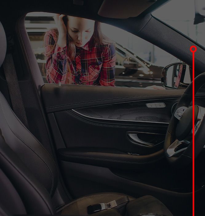 A woman peeking into her car with keys locking inside