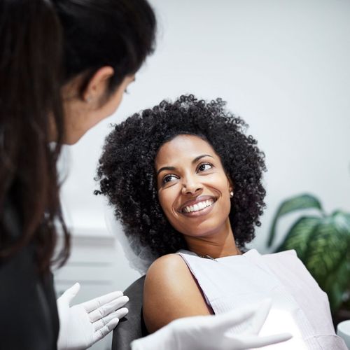 A woman smiling while talking to her dentist during an appointment