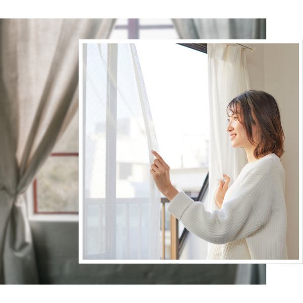woman looking out window through custom drapery