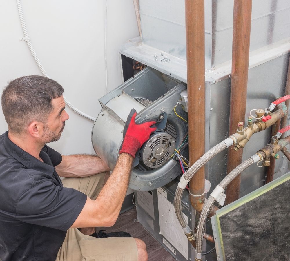 Licensed HVAC technician conducting a detailed safety inspection and furnace repair on a residential heating system. Licensed HVAC technician conducting a detailed safety inspection and furnace repair on a residential heating system.