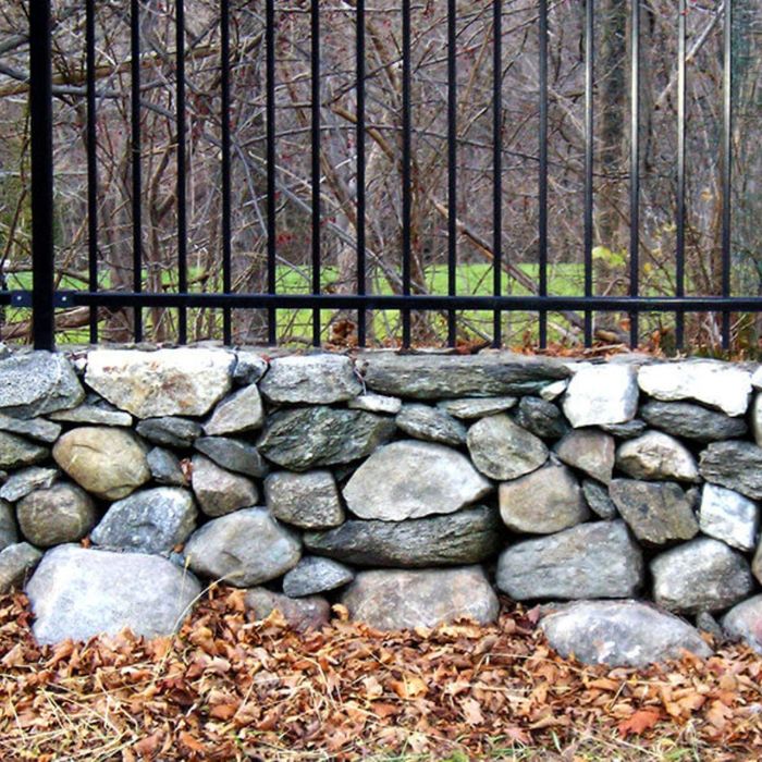 Metal fence mounted on a stone wall