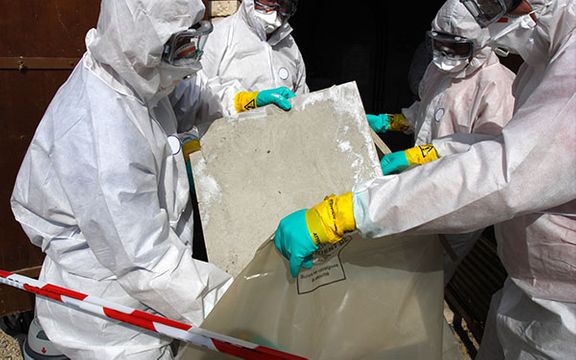 Asbestos removal team disposing of asbestos-containing material