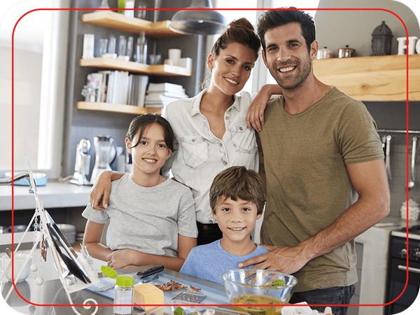 Family of four smiling in their kitchen
