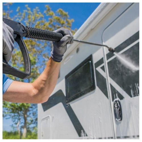 man washing RV trailer