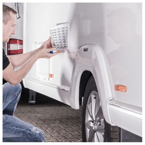 man doing maintenance on RV trailer