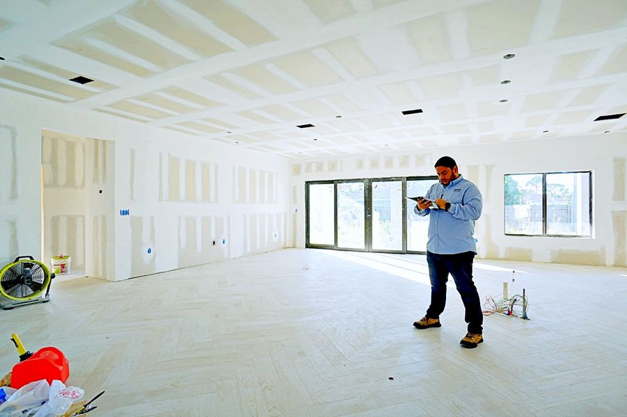 contractor looking at clipboard in room under development