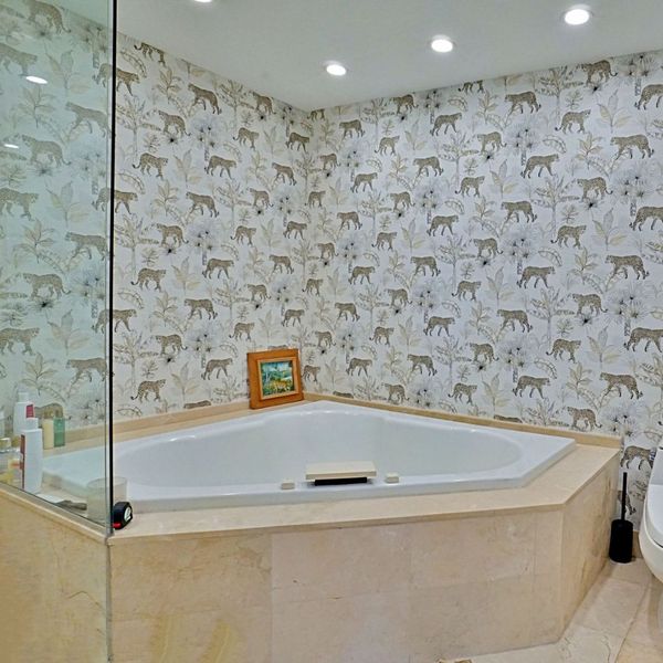 a bathtub set against leopard wall paper
